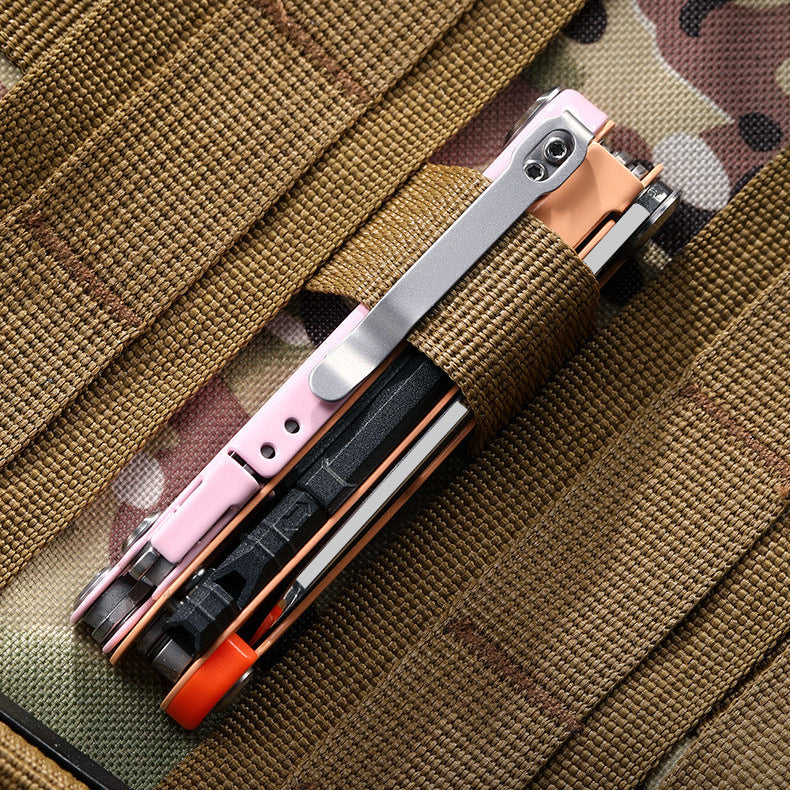 A compact multi-functional tool knife with a rose gold and black finish, shown folded and resting on a tactical vest with camouflage straps. Chinese text is overlaid at the top.
